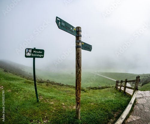 Señales indicativas de madera dentro del Parque Nacional de Los Picos de Europa en un día con niebla