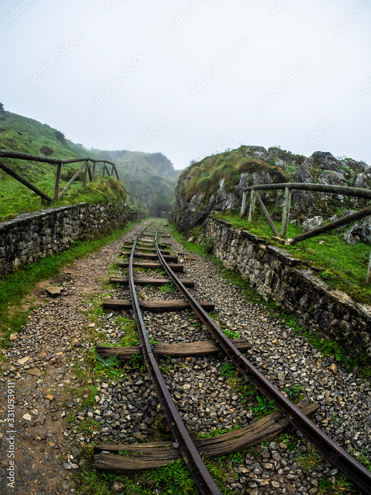Vía de tren en una mina abandonada en los Picos de Europa de Asturias Vía de tren en una mina abandonada en los Picos de Europa de Asturias