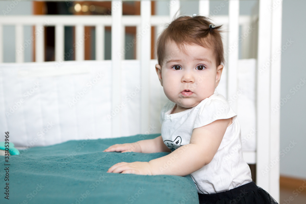 Baby girl looking at camera, Caucasian child is in domestic room Baby girl looking at camera, Caucasian child is in domestic room