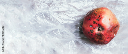 Quadro em tela Spoiled bad red apple on plastic bag background
