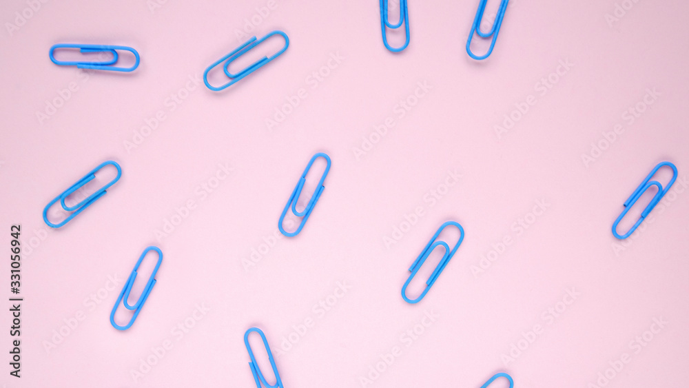 Blue paper clips on a pink background. Back to School Concept Blue paper clips on a pink background. Back to School Concept
