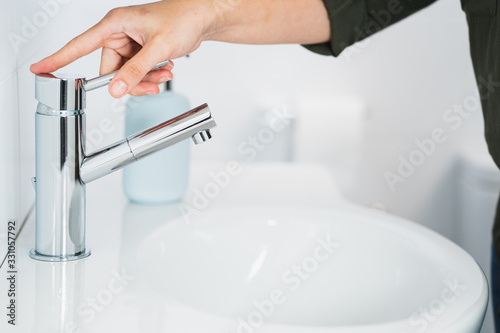 Hygiene. Cleaning Hands. Washing hands with soap. Young woman washing hands with soap over sink in bathroom  closeup. Covid 19. Coronavirus.