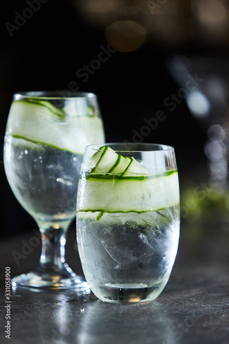 Gin and tonic with cucumber on ice in glass