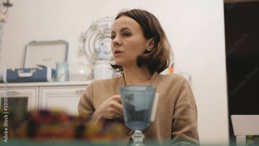 Girl drinks coffee from a cup and chats with friends Girl drinks coffee from a cup and chats with friends