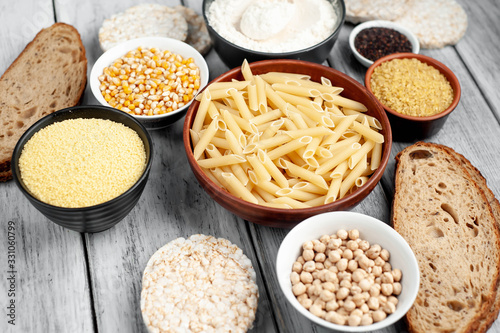 Selection of gluten free food. Chickpeas, bread, couscous, bulgur, pasta, bread, flour, quinoa  on wood background