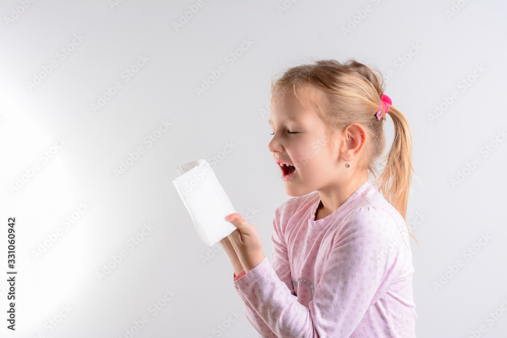 Side view of a child with handkerchief. Sick childe isolated has runny nose. Girl makes a cure for the common cold. Coughing advice from experts who seek to minimize risk of viral transmission Side view of a child with handkerchief. Sick childe isolated has runny nose. Girl makes a cure for the common cold. Coughing advice from experts who seek to minimize risk of viral transmission