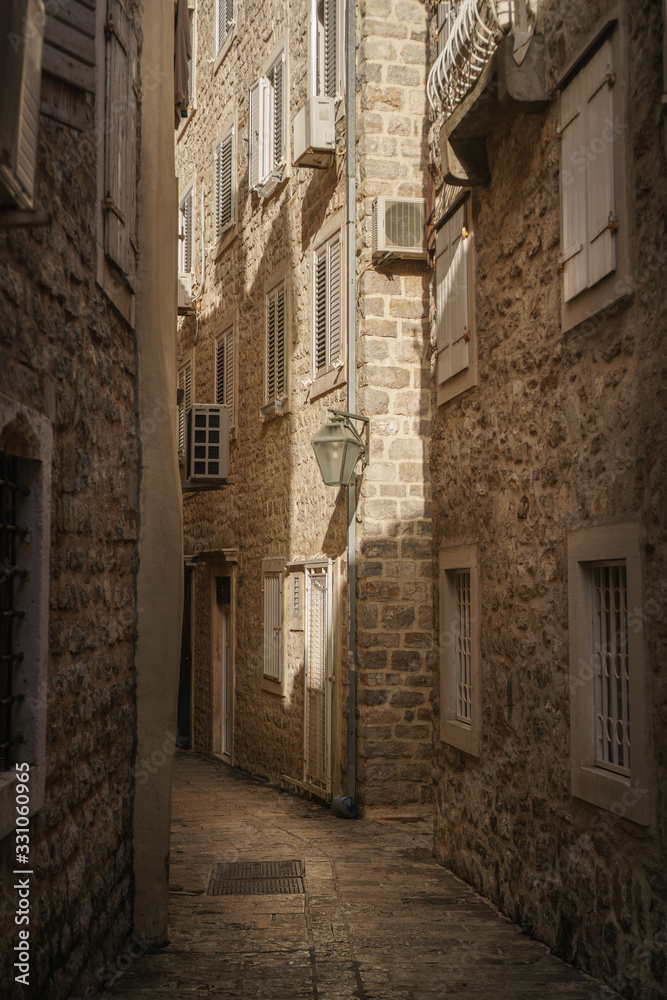 Fototapeta premium Old narrow street of a European city paved with stones