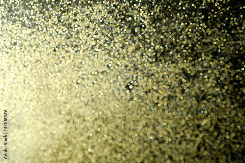 Romantic dreamy golden bokeh. glitter lights grunge background, glitter defocused. Falling flow of golden glitter dust shiny sparkle bokeh abstract background