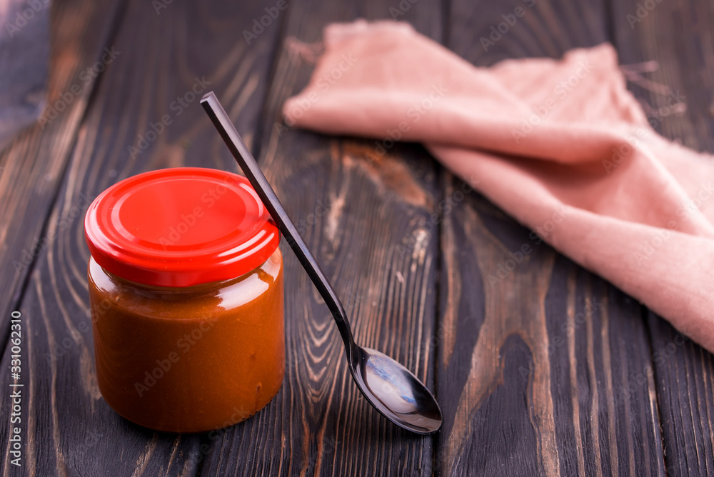 Homemade salted caramel with a spoon and napkin on the table. Homemade salted caramel with a spoon and napkin on the table.