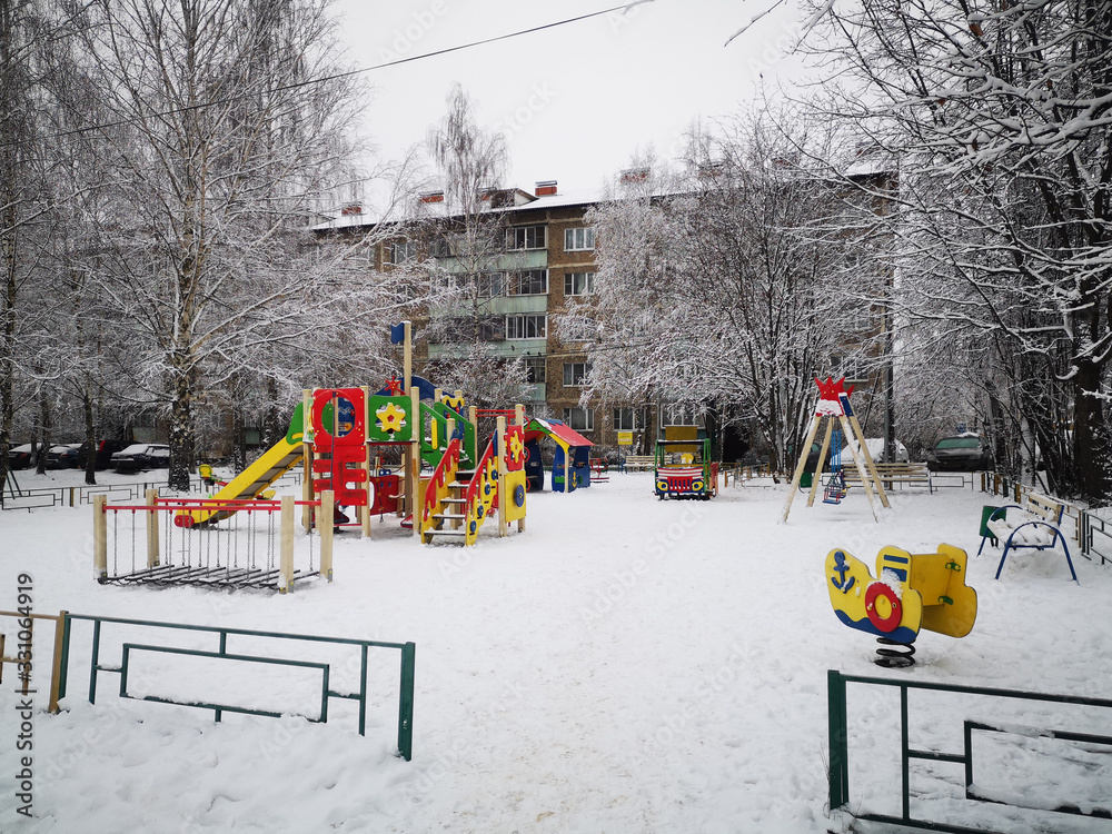 Empty colorful playground in the yard in the park, sports complex in winter Empty colorful playground in the yard in the park, sports complex in winter