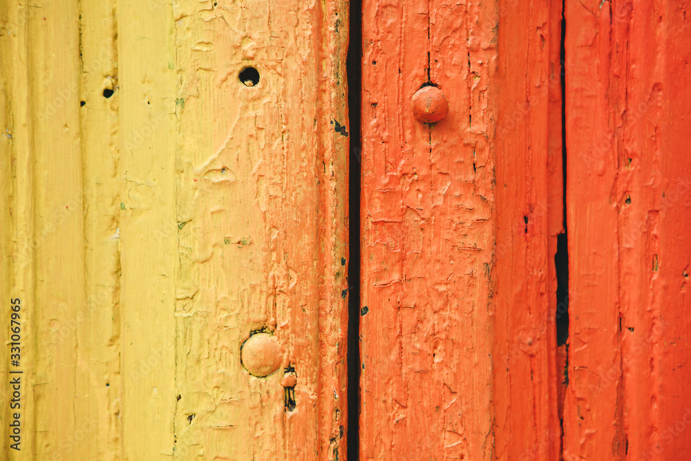 Close-up of a gradient yellow and red colored board with cracks from old age.