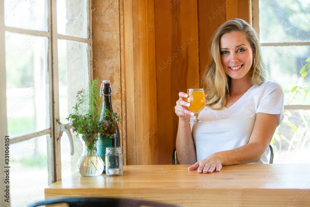 © elnariz - Casual lifestyle portrait of a beautiful woman lounging relaxed at local pub brewery with friends, drinking craft beer