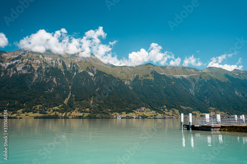 View of lake with clear turquoise water. Mountains are shrouded in haze