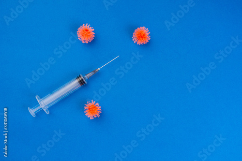 syringe and three simulated virus on blue background