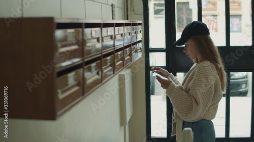 Smiling girl taking junk mail out the posting box