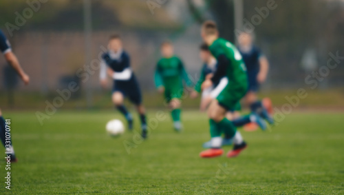 Blurred background of soccer players kicking match on grass pitch. Blurred football athletes running after ball © matimix