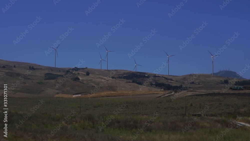 Row of windmills turning , wind power turbines generating clean renewable energy. Concept of green energy solution to climate change. Row of windmills turning , wind power turbines generating clean renewable energy. Concept of green energy solution to climate change.