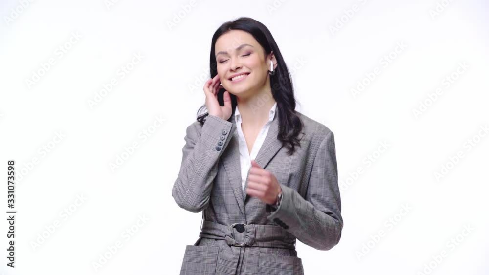 Businesswoman with earphones dancing isolated on yellow Businesswoman with earphones dancing isolated on yellow