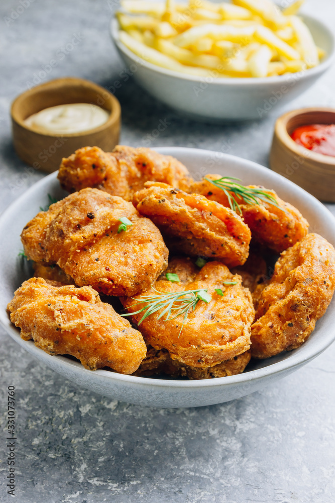 Fried crispy chicken nuggets with french fries and ketchup on light gray background. Seletive focus Fried crispy chicken nuggets with french fries and ketchup on light gray background. Seletive focus