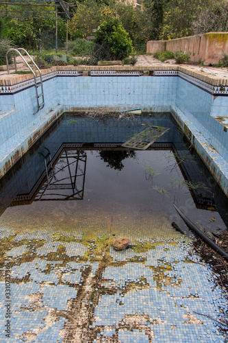 a dirty and abandoned pool with little water, abandoned pool, abandoned swimming pool, ruined pool