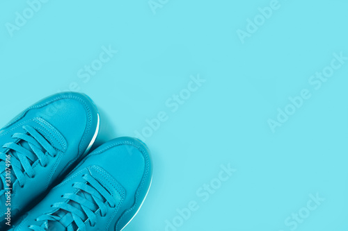Bright blue sneakers on pastel blue background. Concept of woman sport and healthy lifestyle in monochrome. Place for text  flat lay  top view.