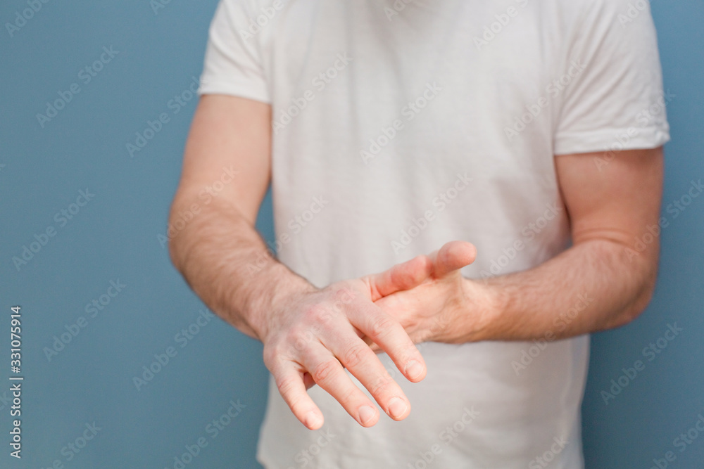 young man in a surgical mask uses hand sanitizer to clean his hands from germs young man in a surgical mask uses hand sanitizer to clean his hands from germs