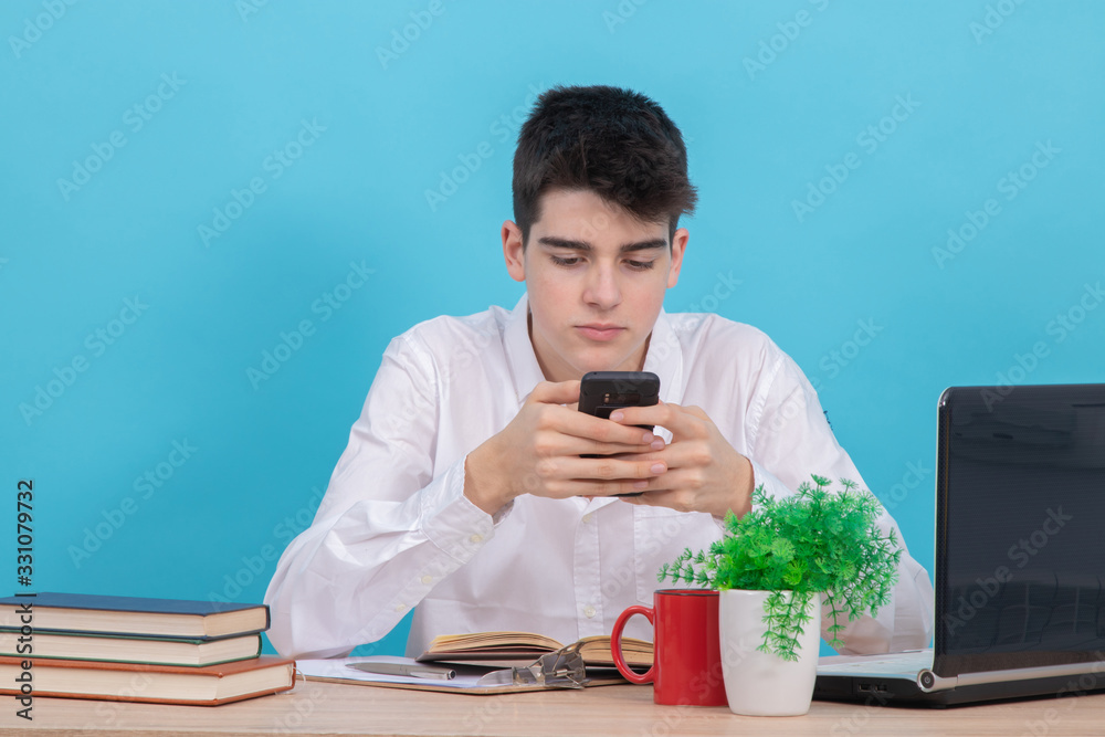 student at the desk isolated on color background at the table with books and school supplies student at the desk isolated on color background at the table with books and school supplies