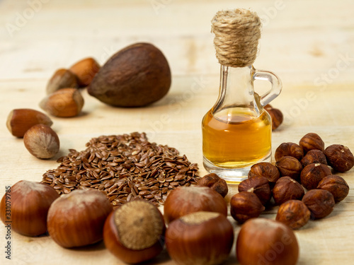 Oil in a bottle and nuts on a wooden background