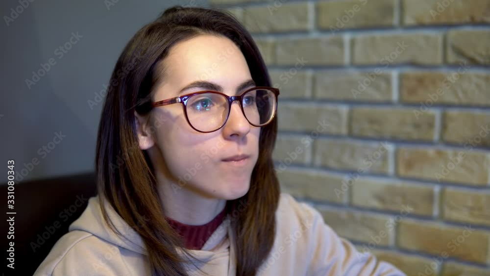 A young woman is eating a slice of pizza. Woman sitting in a restaurant and eating pizza close-up. A young woman is eating a slice of pizza. Woman sitting in a restaurant and eating pizza close-up.