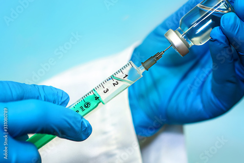 Vaccine in a bottle with a syringe on a blue background.The concept of medicine, healthcare and science