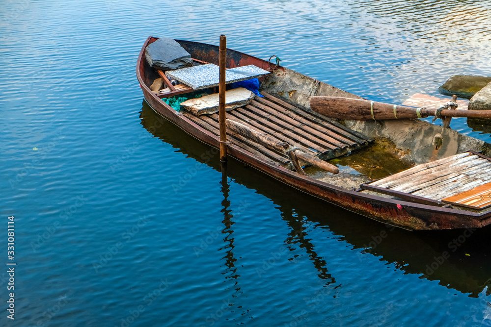 Wooden boat on blue water with reflection