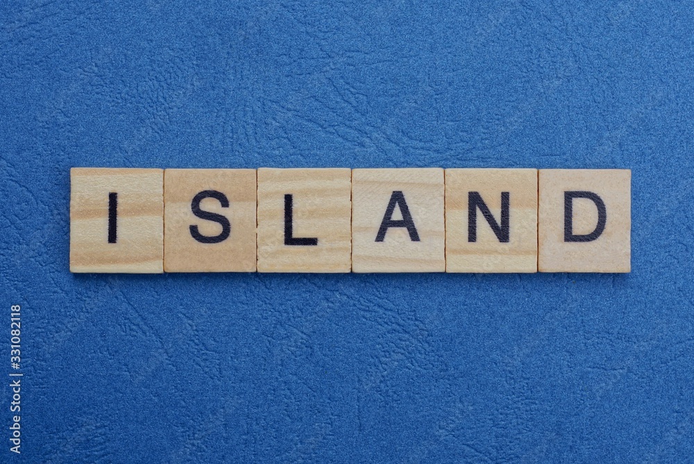 Fototapeta premium gray word island from small wooden letters on a blue table