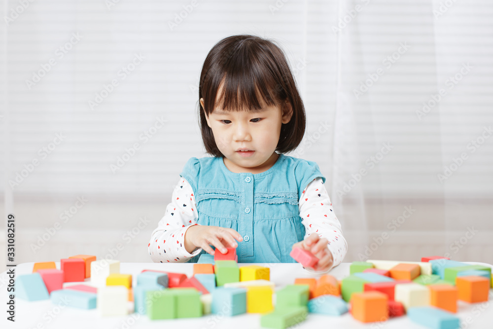 toddler girl playing creative toy blocks at home against white background toddler girl playing creative toy blocks at home against white background