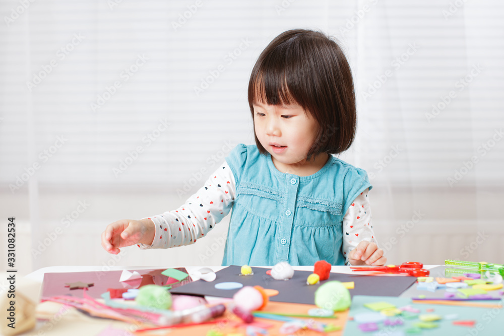 toddler girl learn making Origami at home against white background toddler girl learn making Origami at home against white background