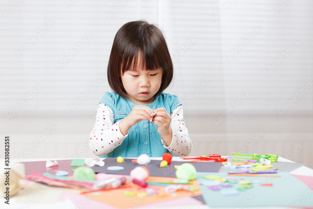 toddler girl learn making Origami at home against white background toddler girl learn making Origami at home against white background