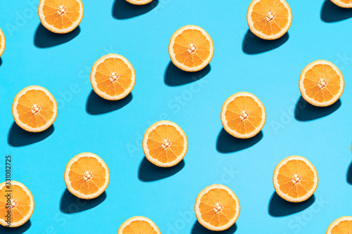 Orange pattern on bright light blue background. Minimal flat lay food texture. Summer abstract trendy fresh concept.