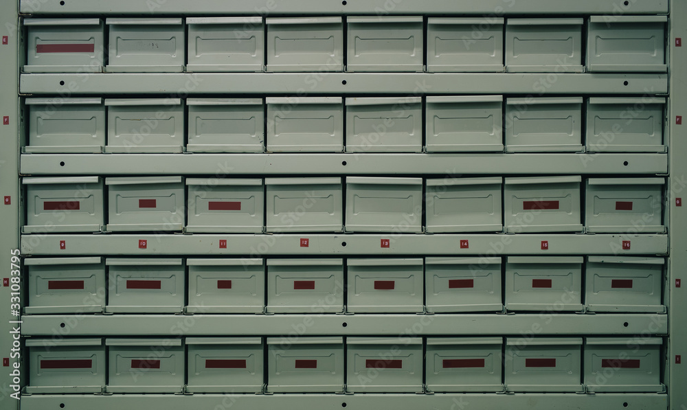 Metal drawers or regals for storing different parts. Fire proof containers at a service or parts warehouse. Side angle view.