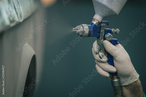 Foto Man with automotive air spray gun in action during the restoration of a vintage car