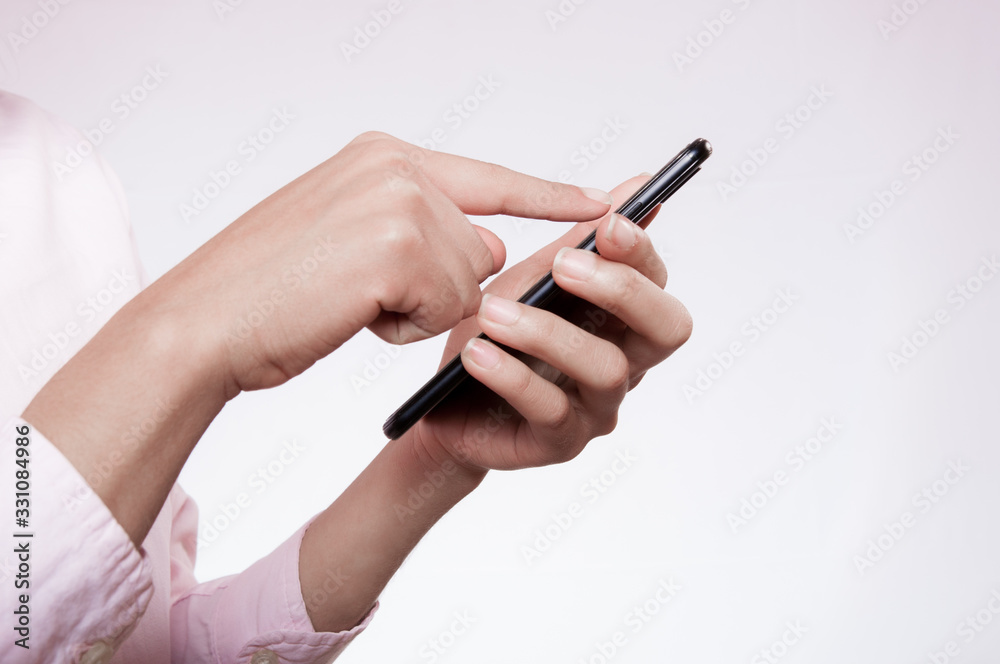woman hands using a cell phone on pink background woman hands using a cell phone on pink background
