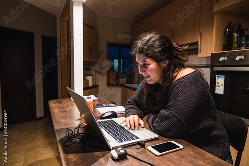 Young spanish girl teleworking at home because of the restrictions given by spanish government due to coronavirus COVID-19 sanitary crysis photo