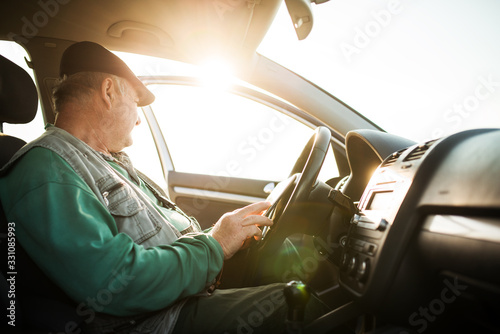 Senior farmer using tablet while sitting in the car