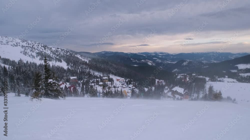 Mountain hazy and cloudy morning snowstorm view. Ski resort Dragobrat, Carpathian mountains, Ukraine. There is slight camera twitch because of strong wind. Mountain hazy and cloudy morning snowstorm view. Ski resort Dragobrat, Carpathian mountains, Ukraine. There is slight camera twitch because of strong wind.