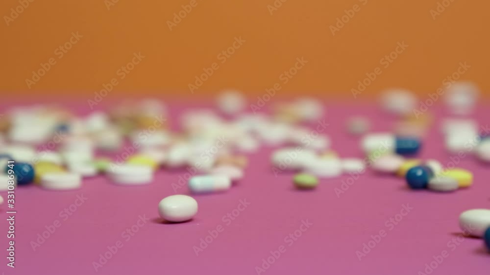 Pills were scattered across the pink surface. Pills were scattered across the pink surface.