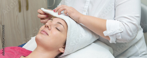 Face skin care. Beautician applying beauty oil mask on face using brush In spa salon