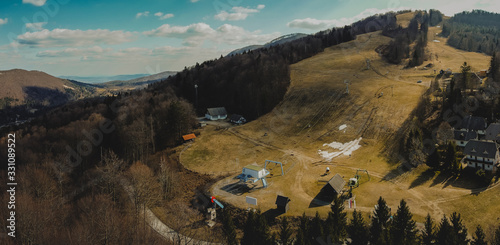 Aerial photo of a small ski resort during dry arid winter. Loss of income due to bad and dry weather without snow, problems of today ski resorts, like in Gace, Slovenia photo