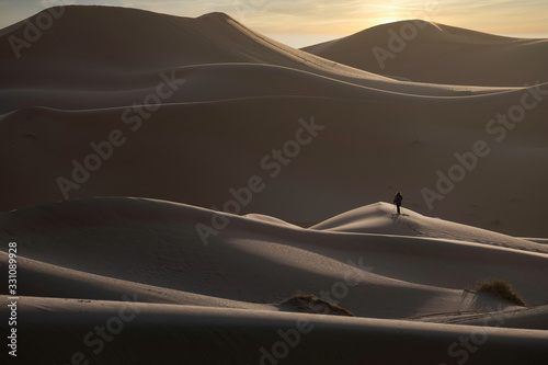 Fototapeta Naklejka Na Ścianę i Meble -  Lone Figure in Sand Dunes, Sahara Desert, Morocco