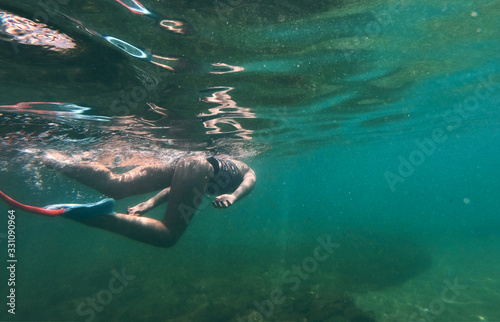 underwater girl snorkeling in crystal clear water beach