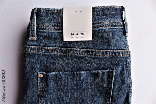 Blue jeans with a size tag photo isolate on white background top view