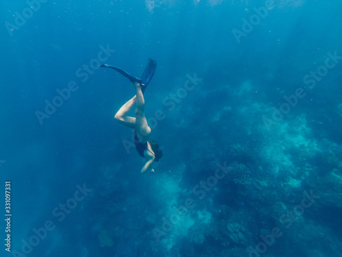 Female extreme swimmer in flippers exploring aquatic oceania depth during getaway adventure on Bali, fit woman wanderer snorkeling in sea during active summer holidays in touristic New Guinea