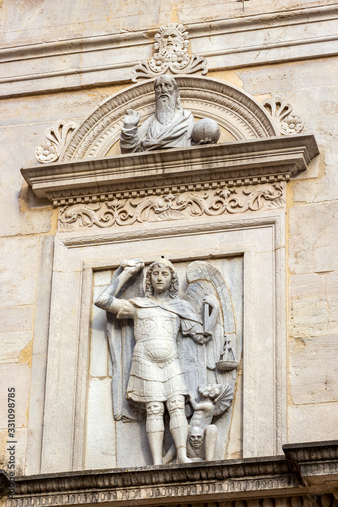 Saint Michael sculpture over the entrance of the Church of San Michele and Arch of Augustus Museum in Fano, Province of Pesaro and Urbino, Marche Region, Italy